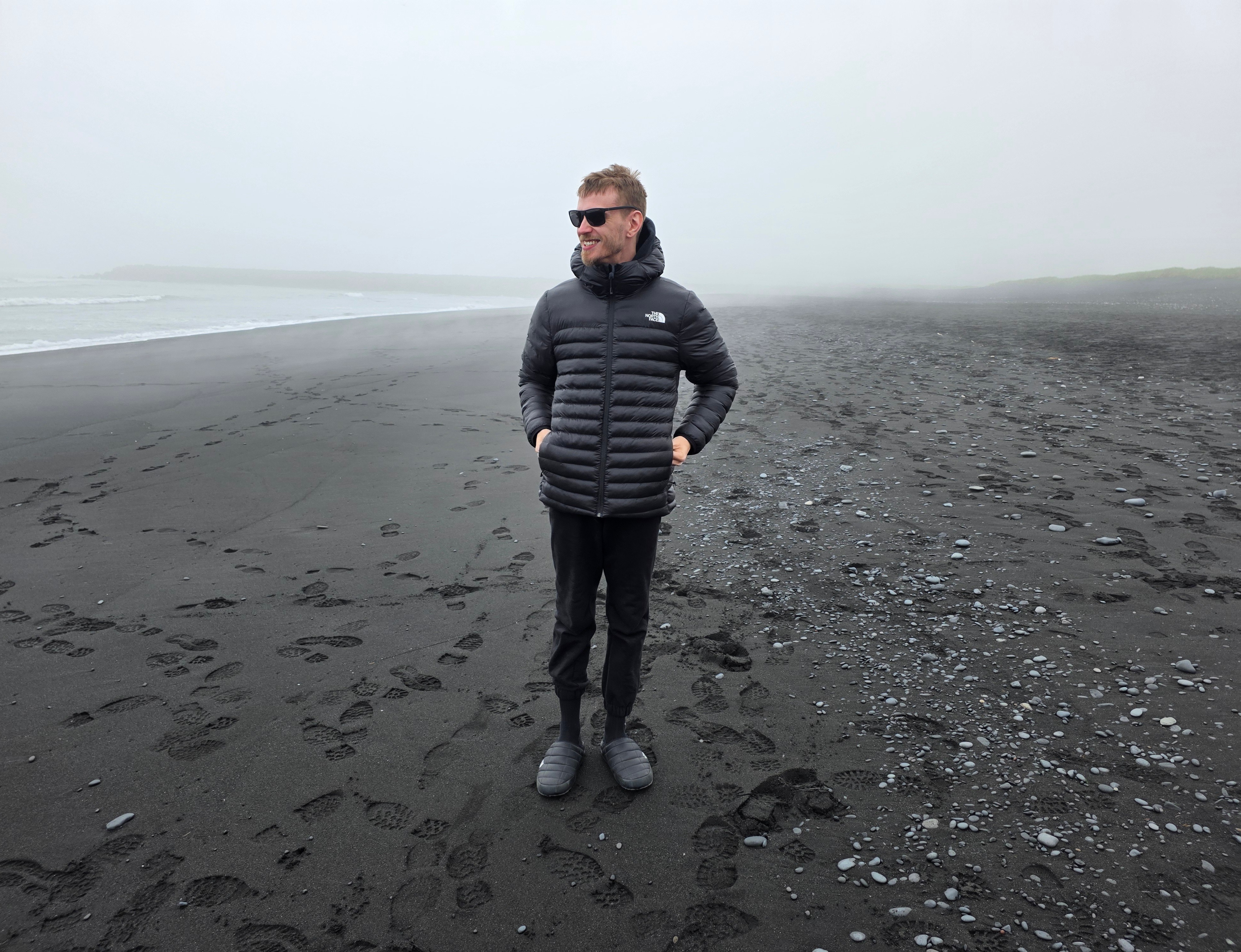 Mitchell Cohen standing on a misty black-sand shoreline